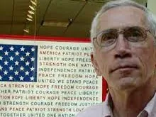 Max Ochs in front of an American flag